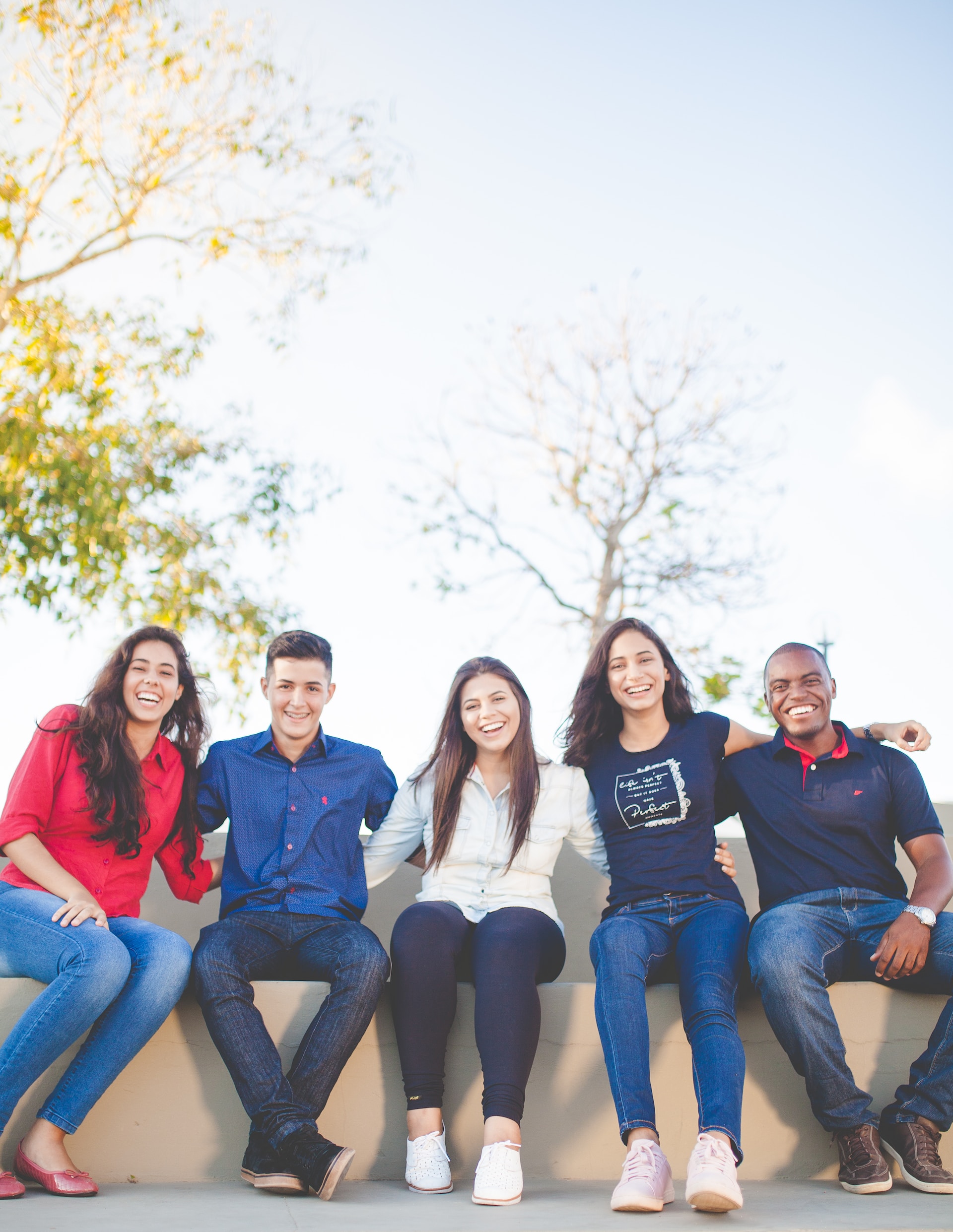 A group of people sitting on top of a bench.